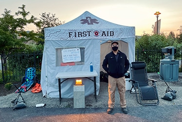 man standing outside medical tent