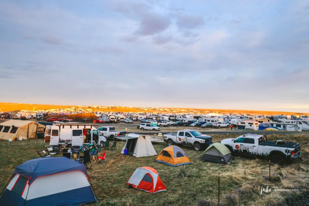 Tents are framed against field and sky at a festival.