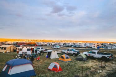 Tents are framed against field and sky at a festival.