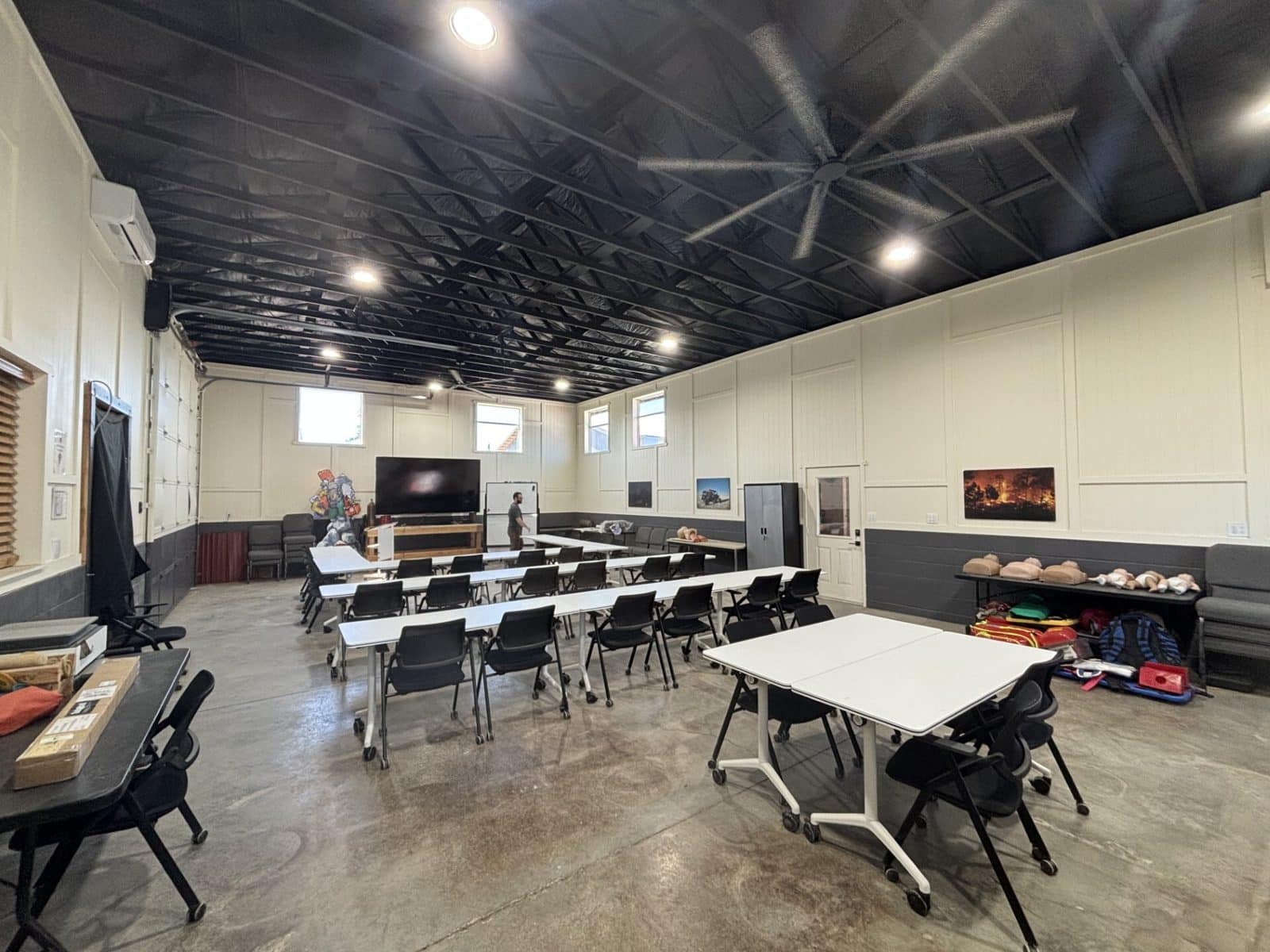 The Adventure Medics classroom at Lava Rock Ranch in Bend, Oregon, set up with tables, a large screen and CPR manikins for Wilderness First Responder training