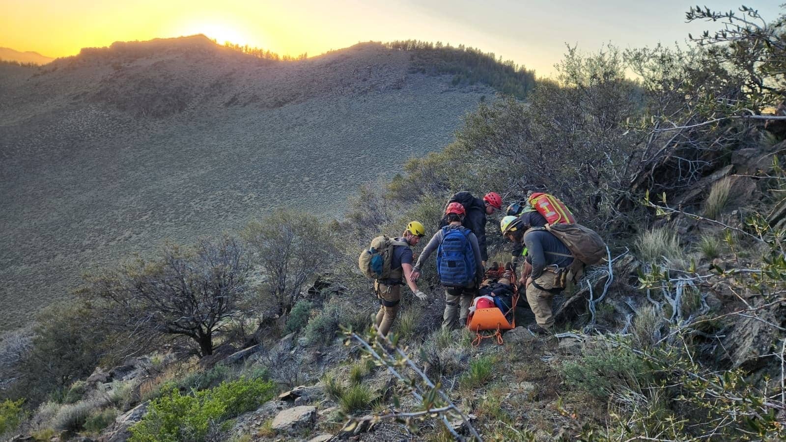 Adventure Medics Wilderness First Responder students packaging a patient in a litter on a ridge at sunset in the Central Oregon backcountry near Bend